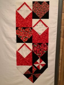 vertical red and white quilt with hearts and open envelopes